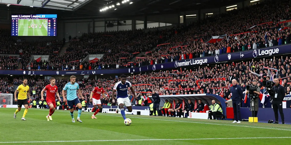 Exciting Premier League match action at https://footballstandings.tv/ showcasing players in vibrant kits, enthusiastic fans, and dynamic competition.